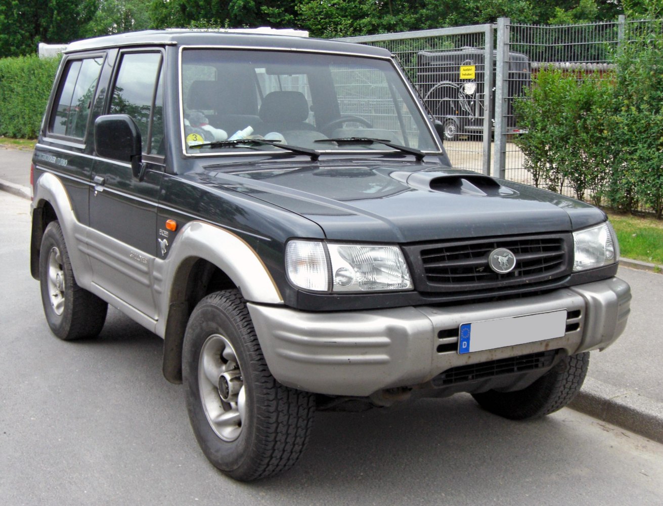Front view of an SUV with hood scoop and two-tone bumper