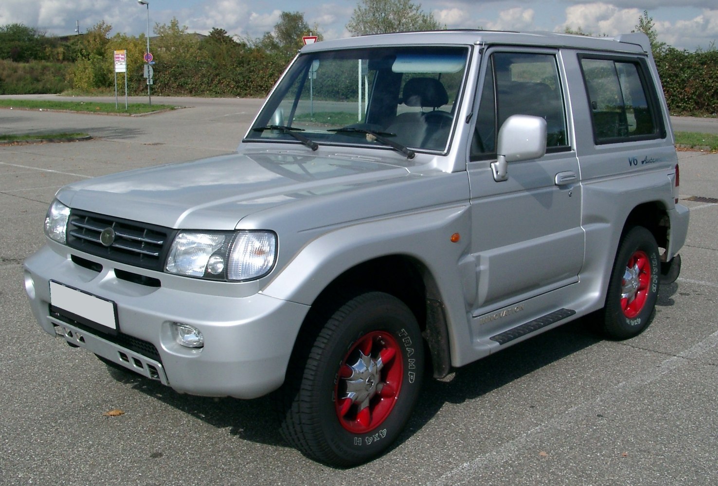 Silver SUV with red rims, front side angle