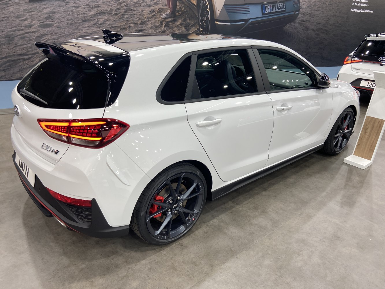 Rear side of hatchback with sporty alloy wheels and dual-color spoiler