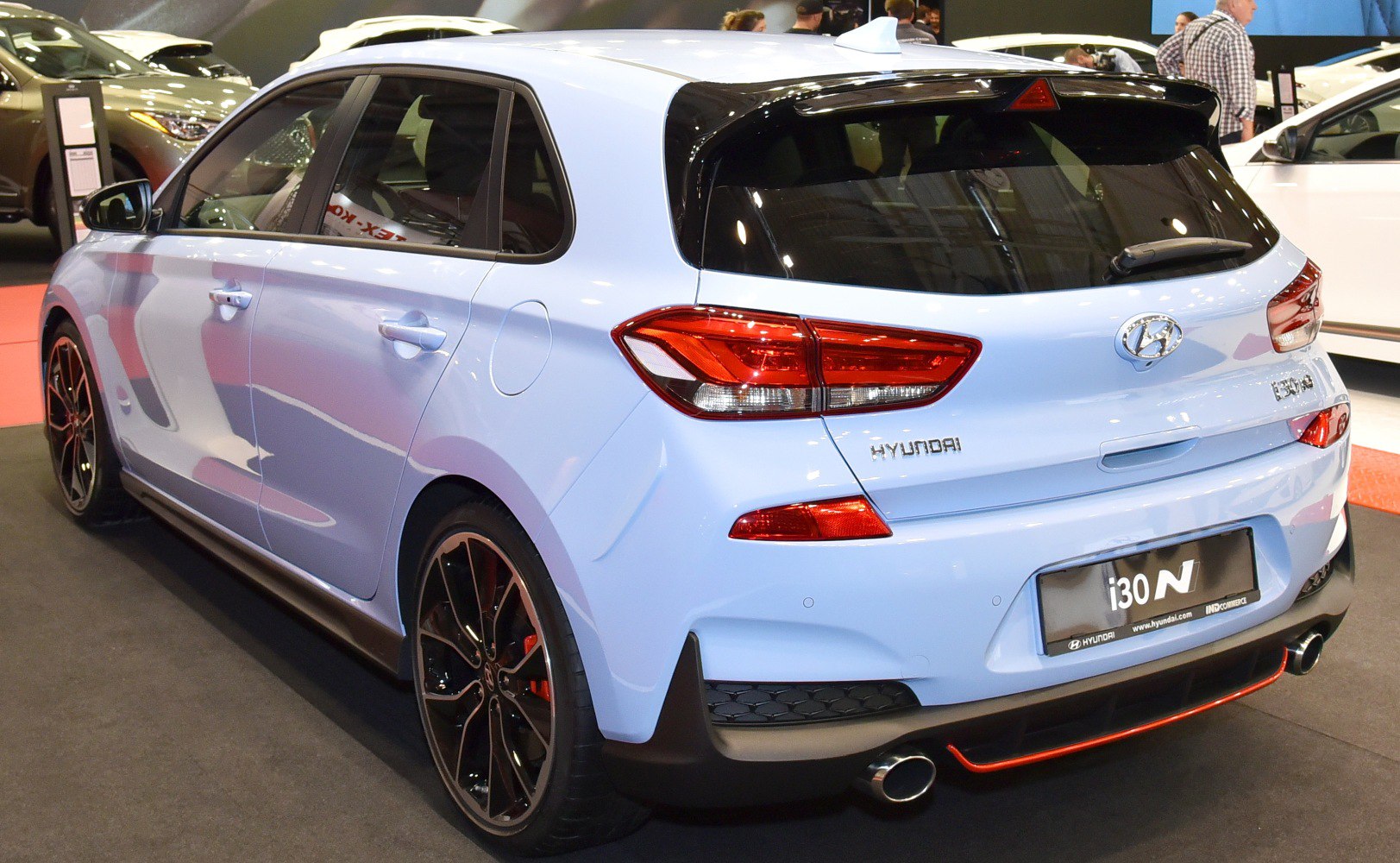 Rear-side view with sporty rear spoiler, dual exhaust, and alloy wheels