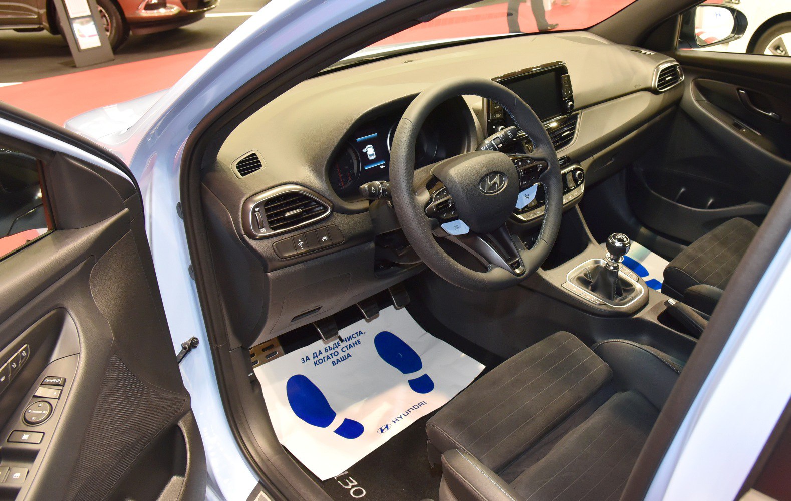 Car interior with dashboard, steering wheel, and manual gearshift