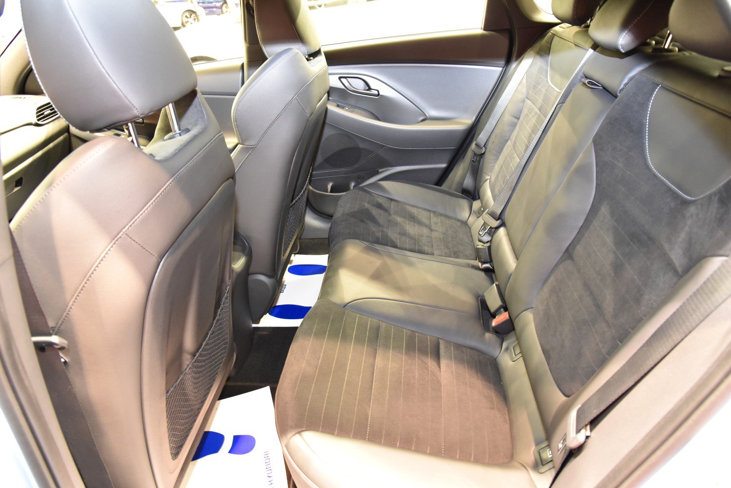Rear seat interior with leather and fabric upholstery in car