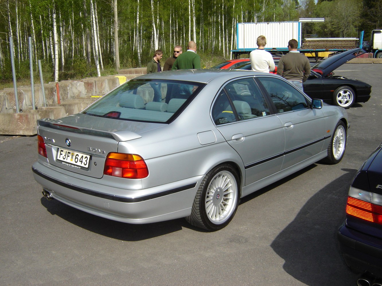 Silver sedan with rear spoiler and multi-spoke wheels