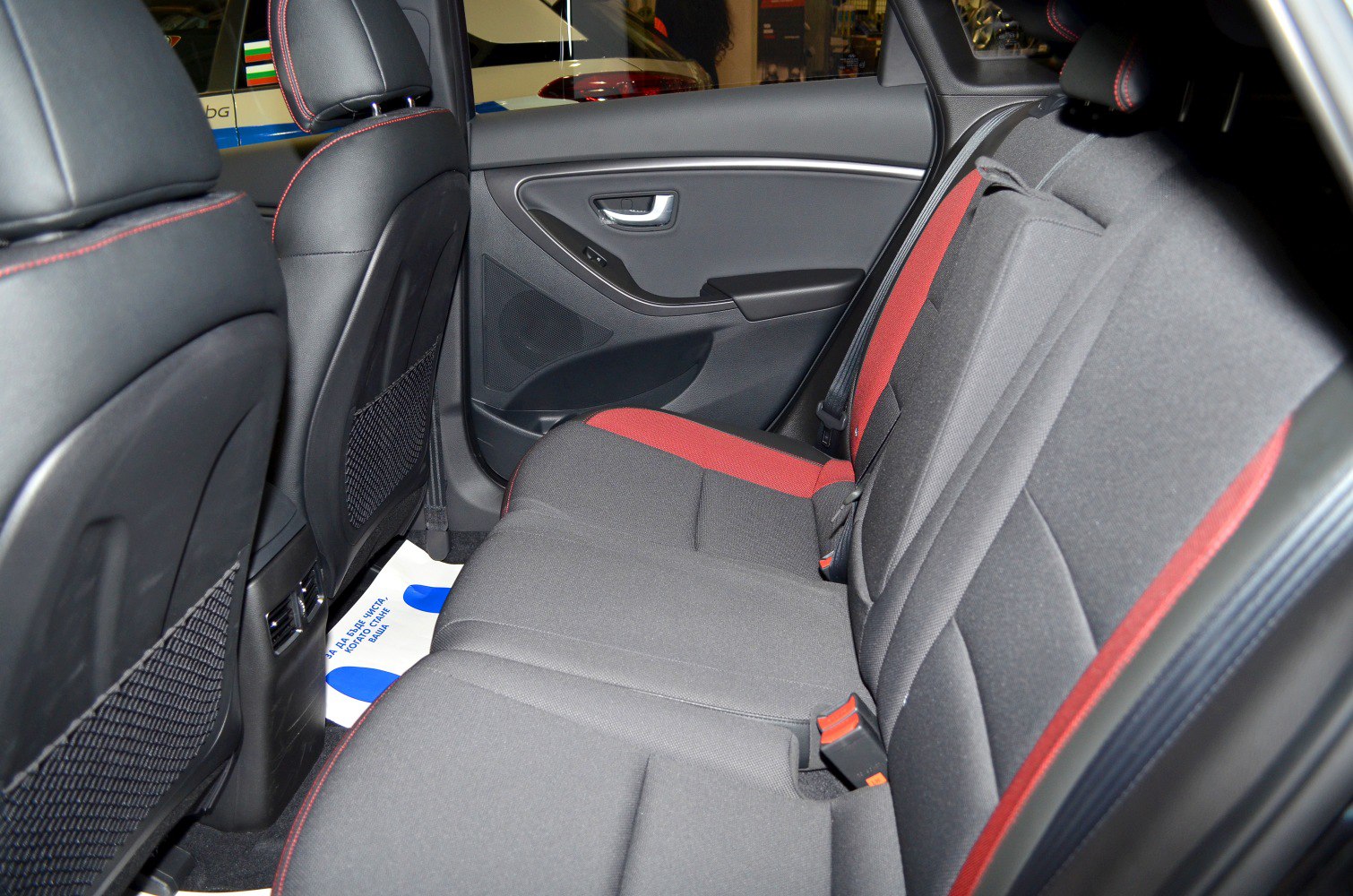 Rear seat upholstery with red accents and interior door panel