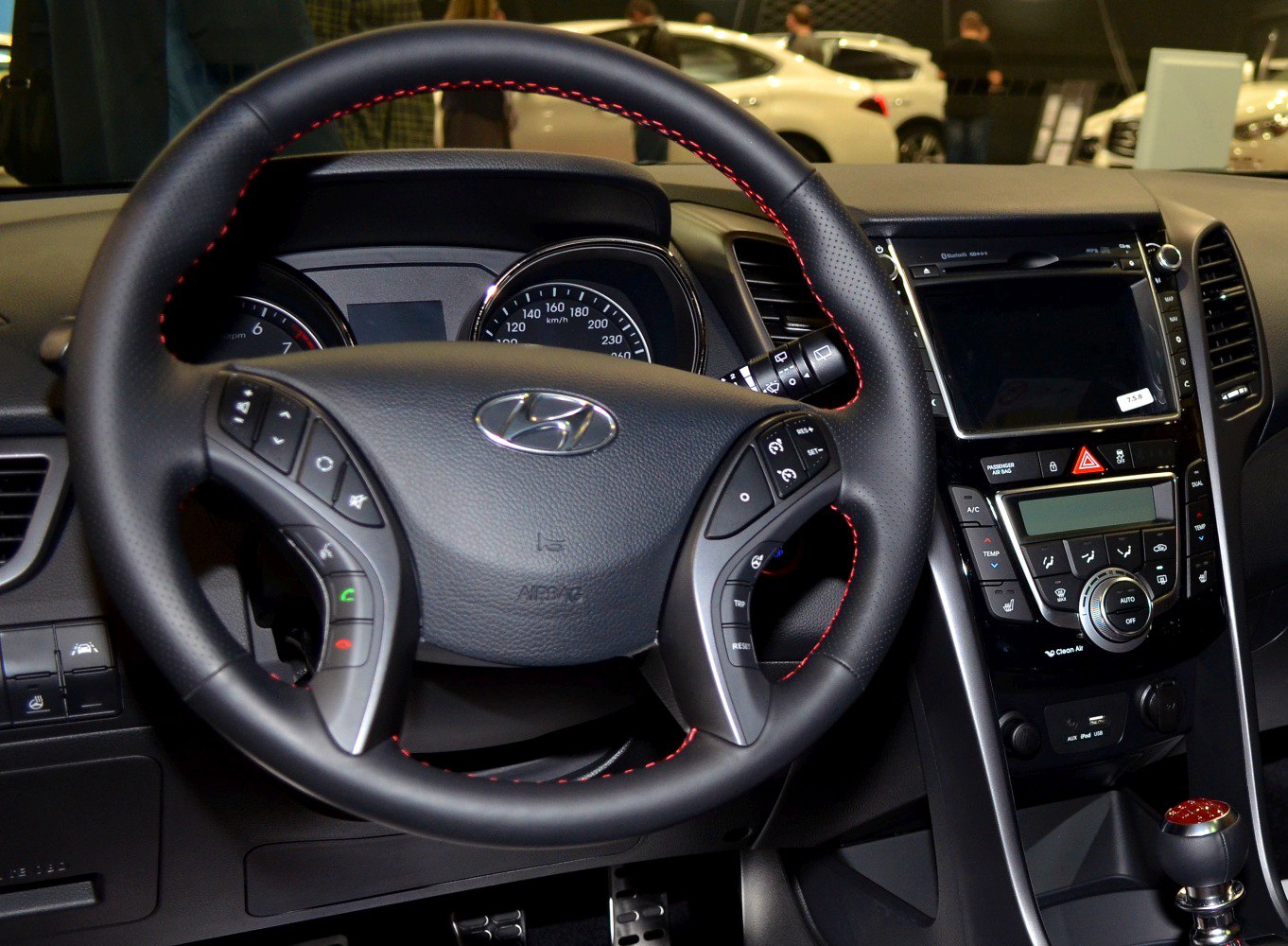 Steering wheel with control buttons and dashboard infotainment display