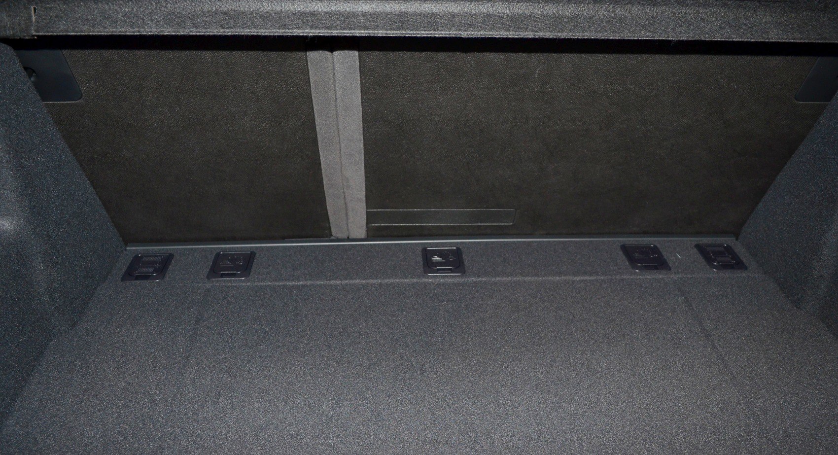 Rear cargo trunk interior with fold-down seat release handles
