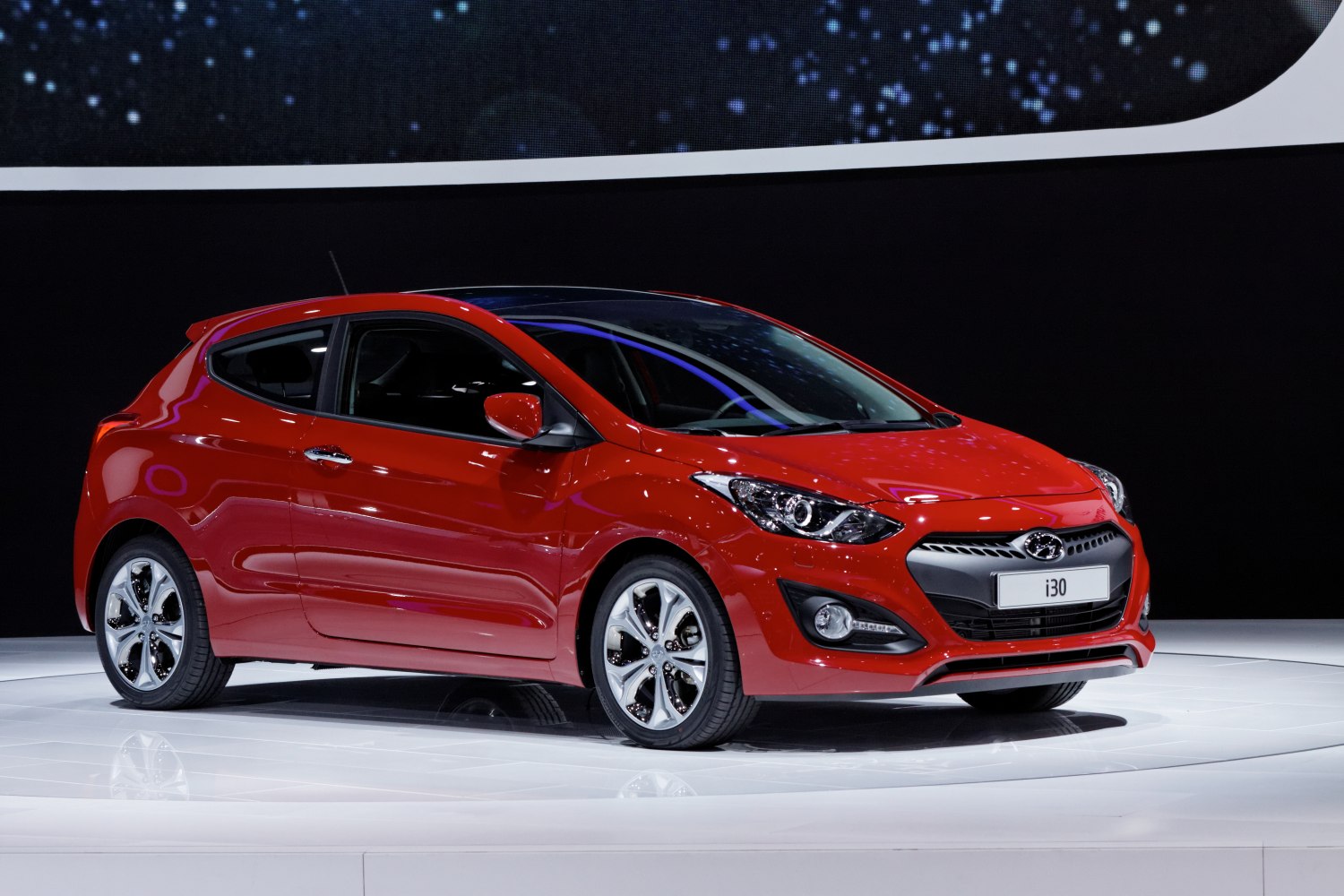 Sporty red hatchback with dynamic front fascia and alloy wheels