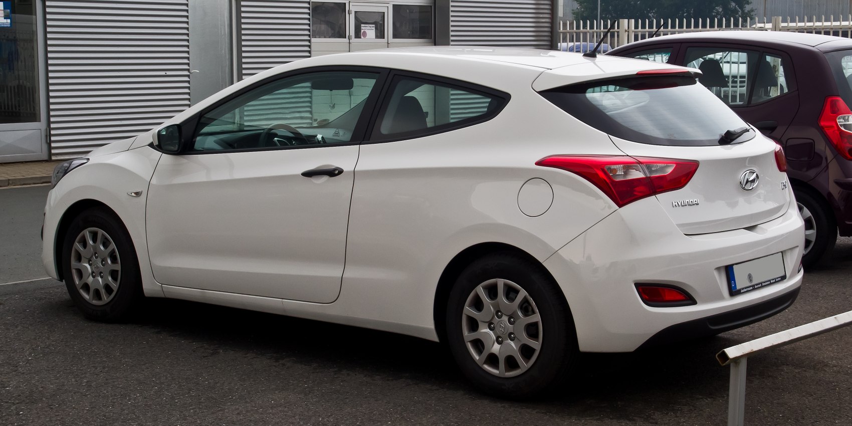 White compact sporty hatchback with distinct rear side profile