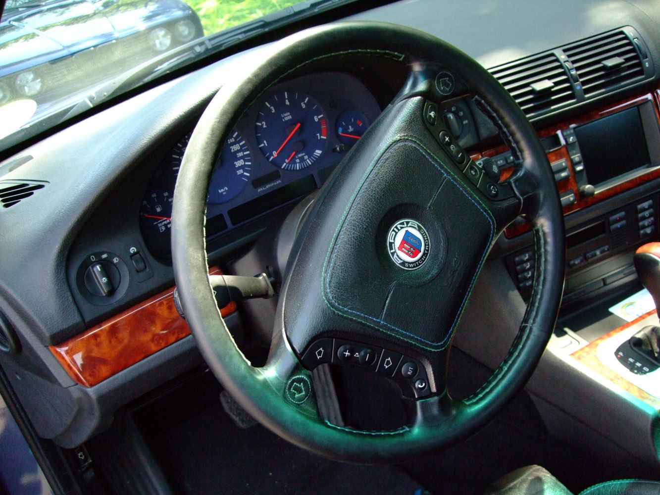 Leather steering wheel with controls and wood-trimmed dashboard
