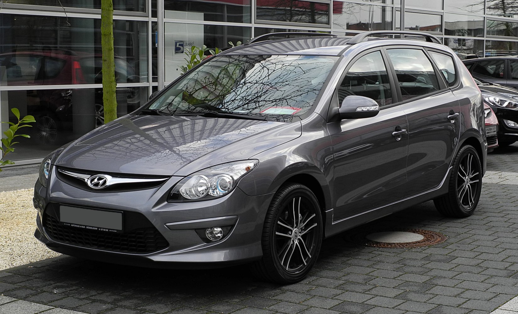 Front and side view of a hatchback with alloy wheels and roof rails