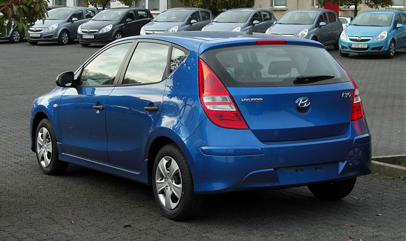 Blue hatchback rear view with distinctive tail lights and five-door layout.