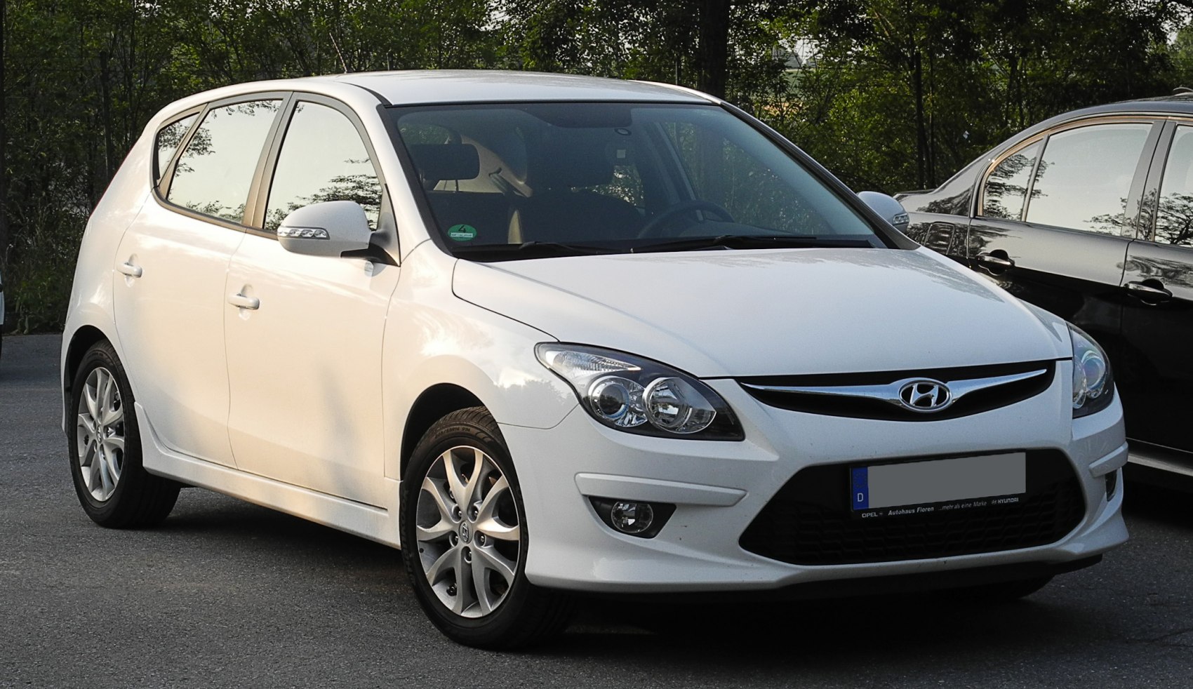 Front and side view of a hatchback with distinctive headlights and alloy wheels