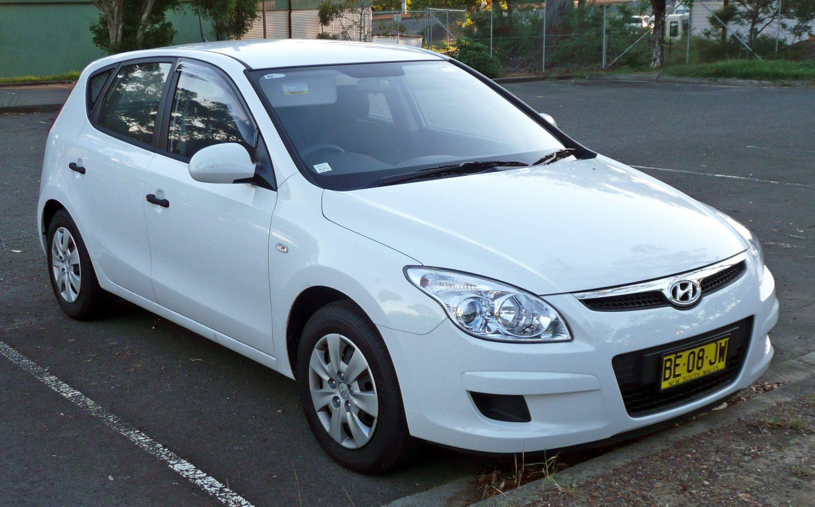 White hatchback with front side view and distinctive headlamps