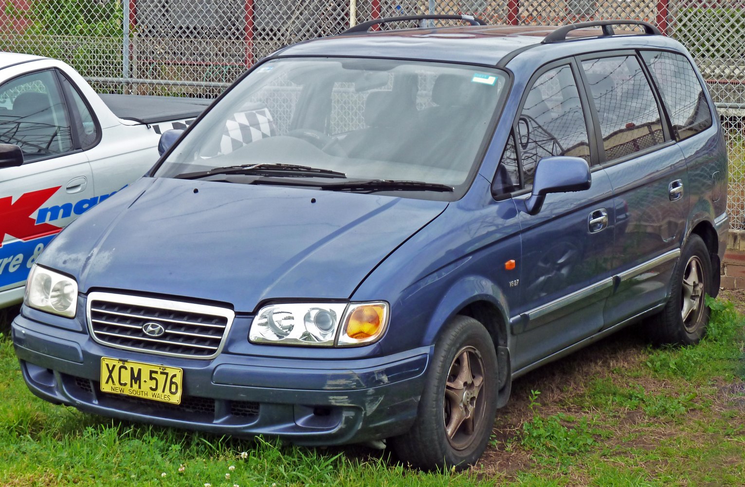 Blue minivan front grille, headlights, side body design