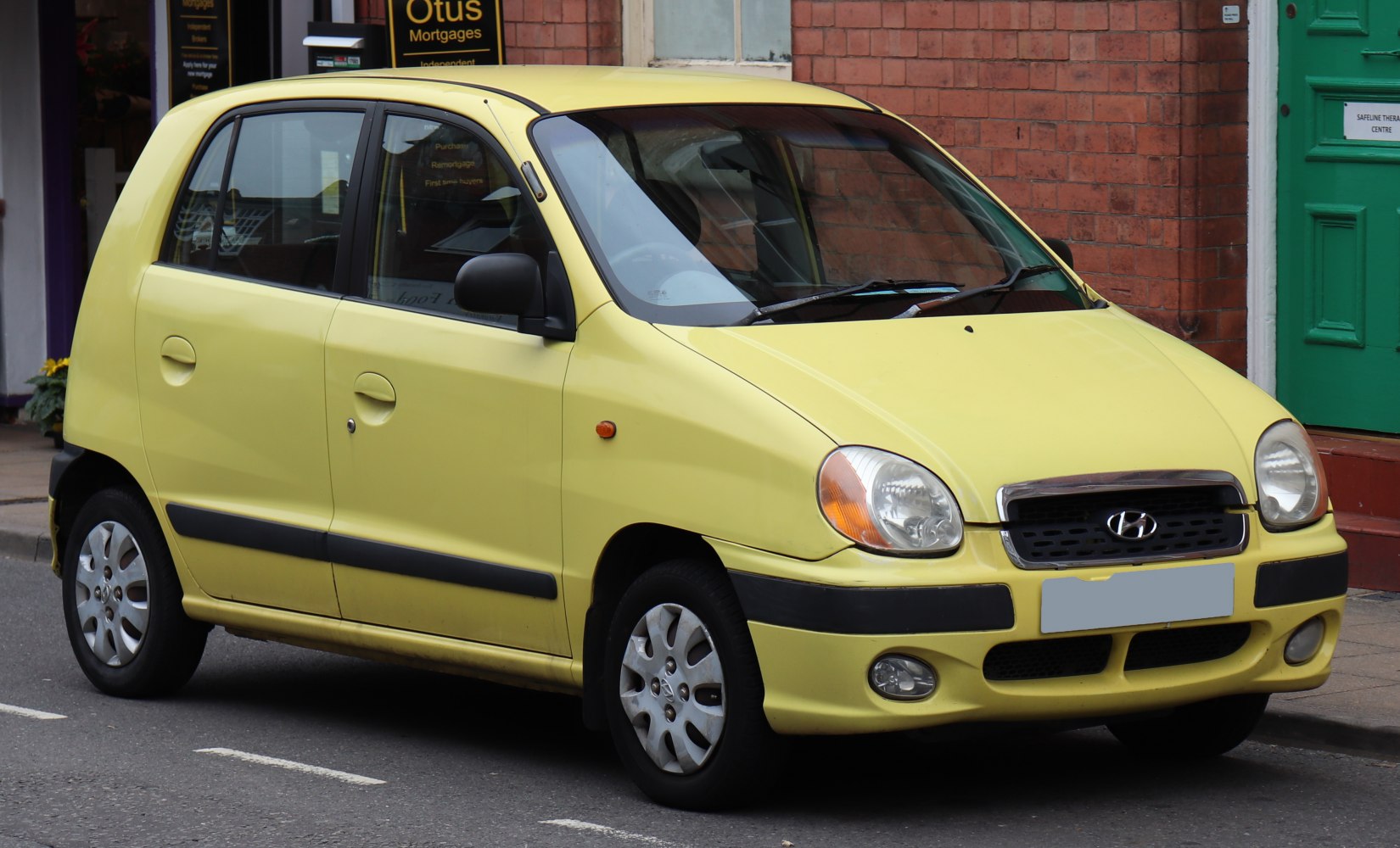 Compact yellow hatchback with rounded headlights and black side trim