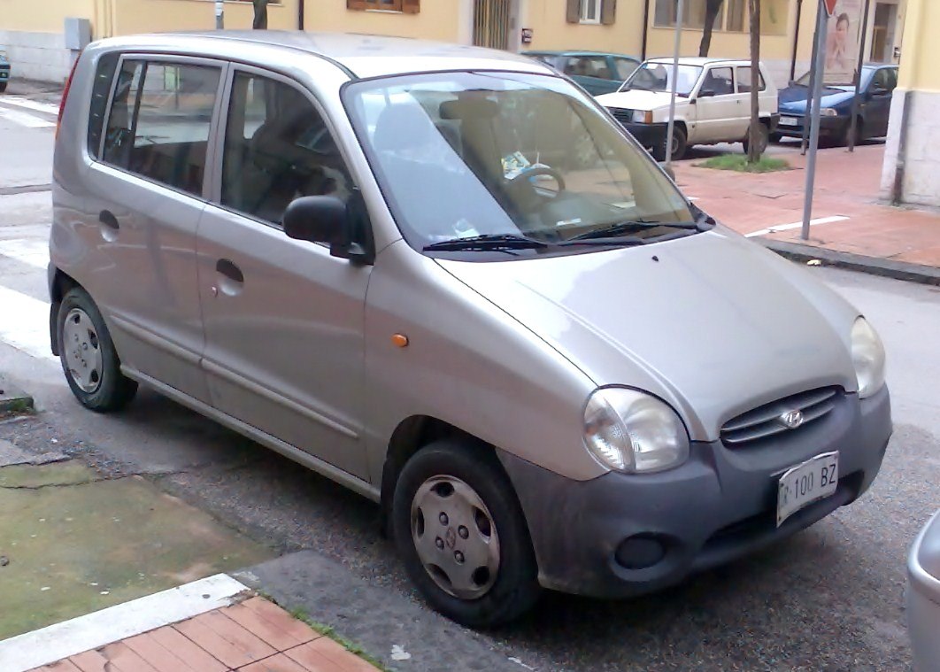 Compact silver hatchback with rounded headlights and tall design.