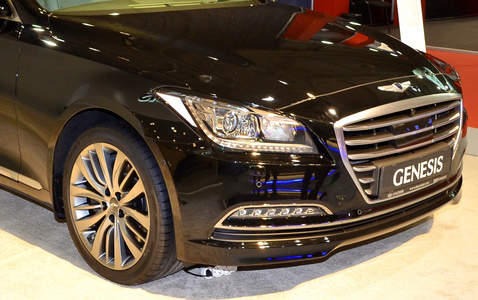 Front grille, LED headlights, and alloy wheel of luxury sedan