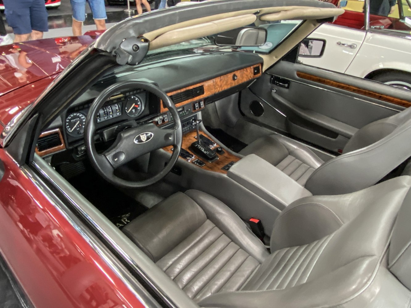 Classic wood trim dashboard with leather bucket seats in a convertible