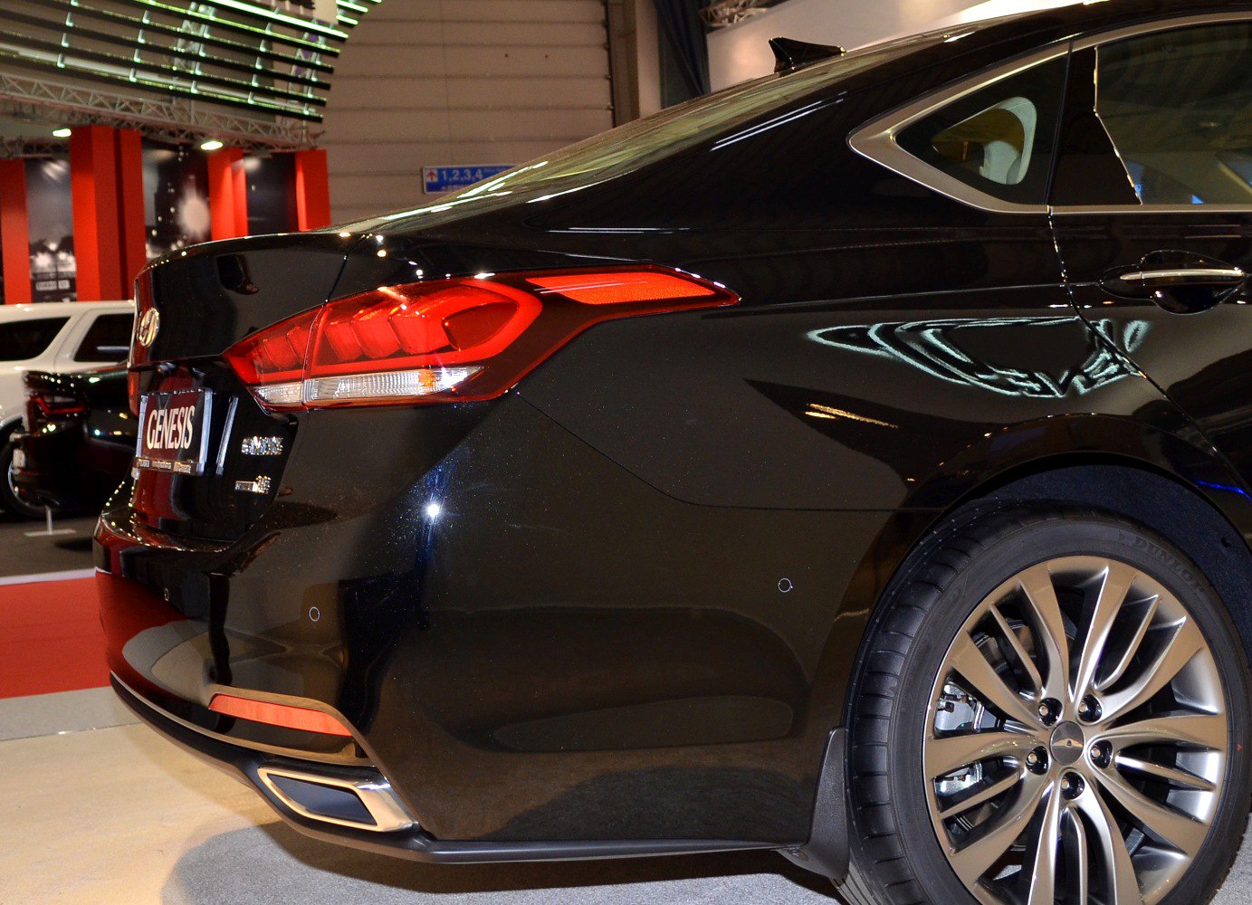 Rear tail light and alloy wheel detail on a sleek sedan rear quarter.