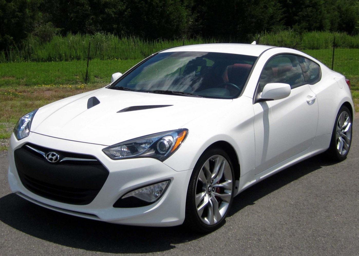 White sporty coupe with hood vents and sleek headlights