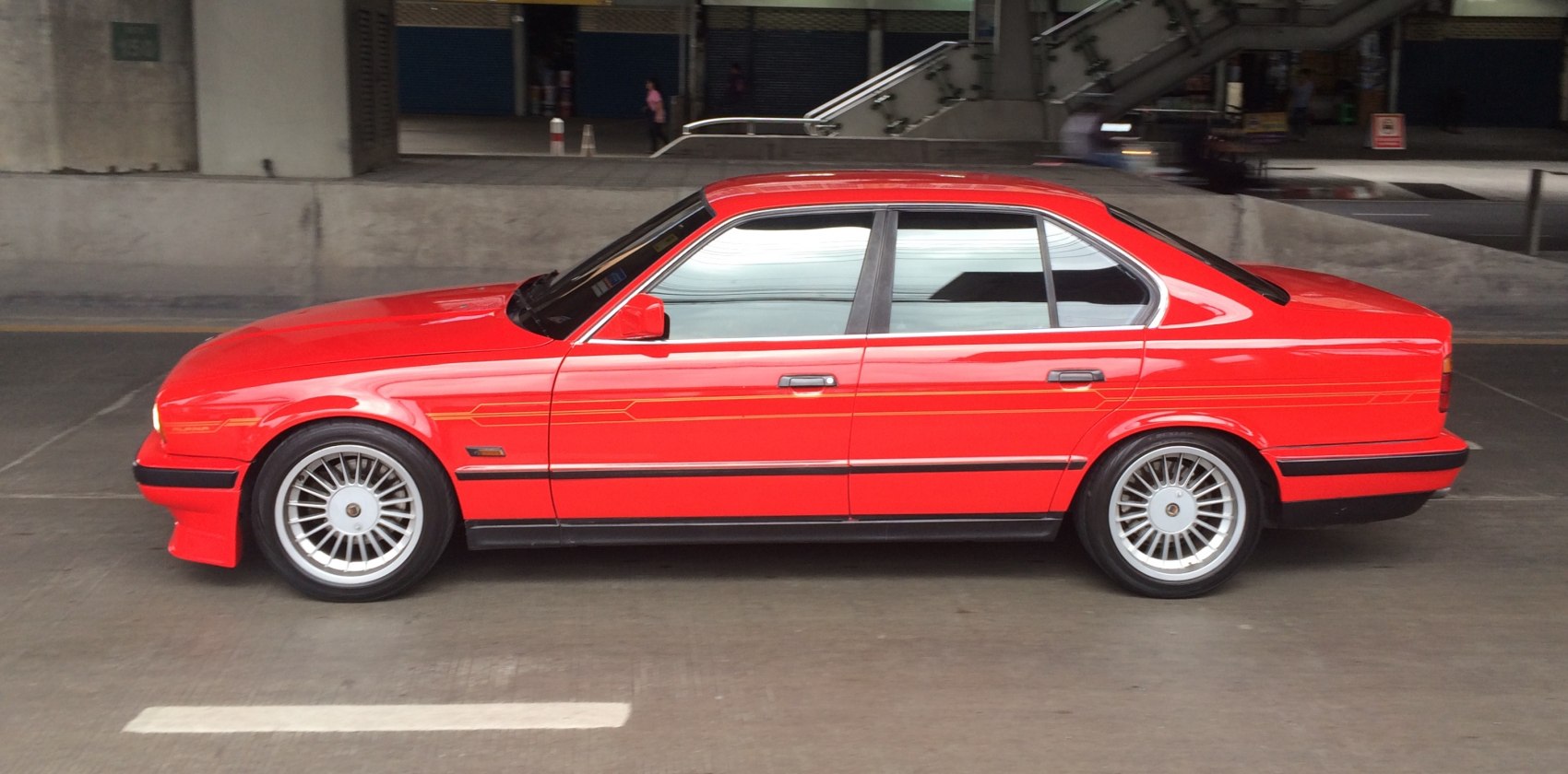 Red sedan with vintage alloy wheels and sporty styling