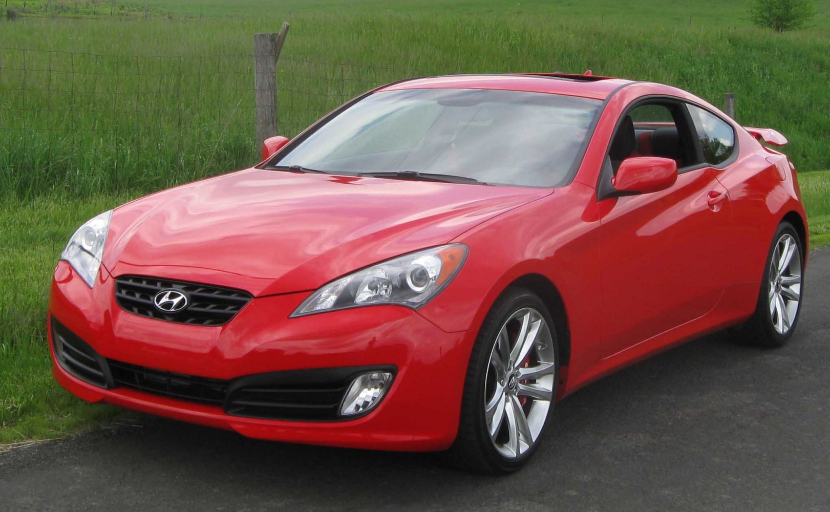 Red sporty coupe with aerodynamic headlights and alloy wheels