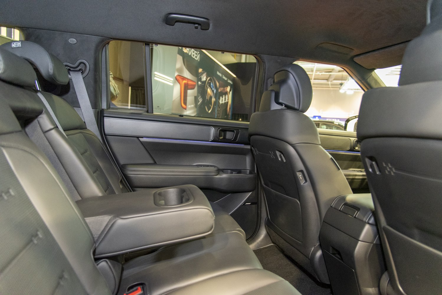 Rear interior with leather seats, armrest, cup holders and door panel