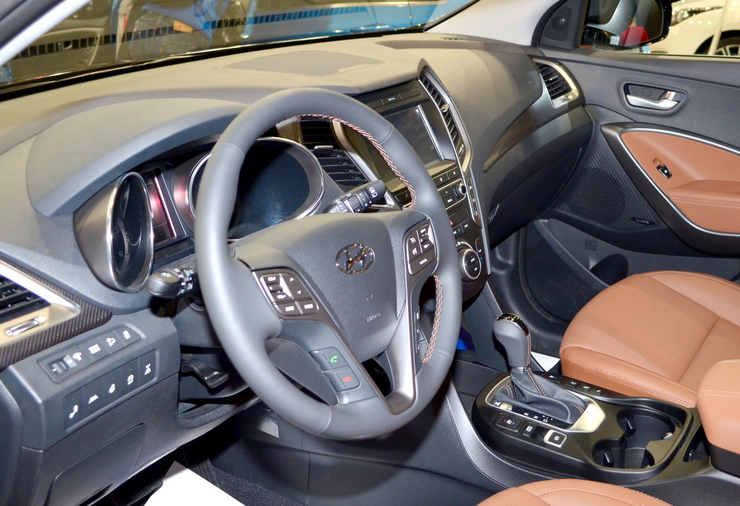 Ergonomic steering wheel and brown leather seats in car interior