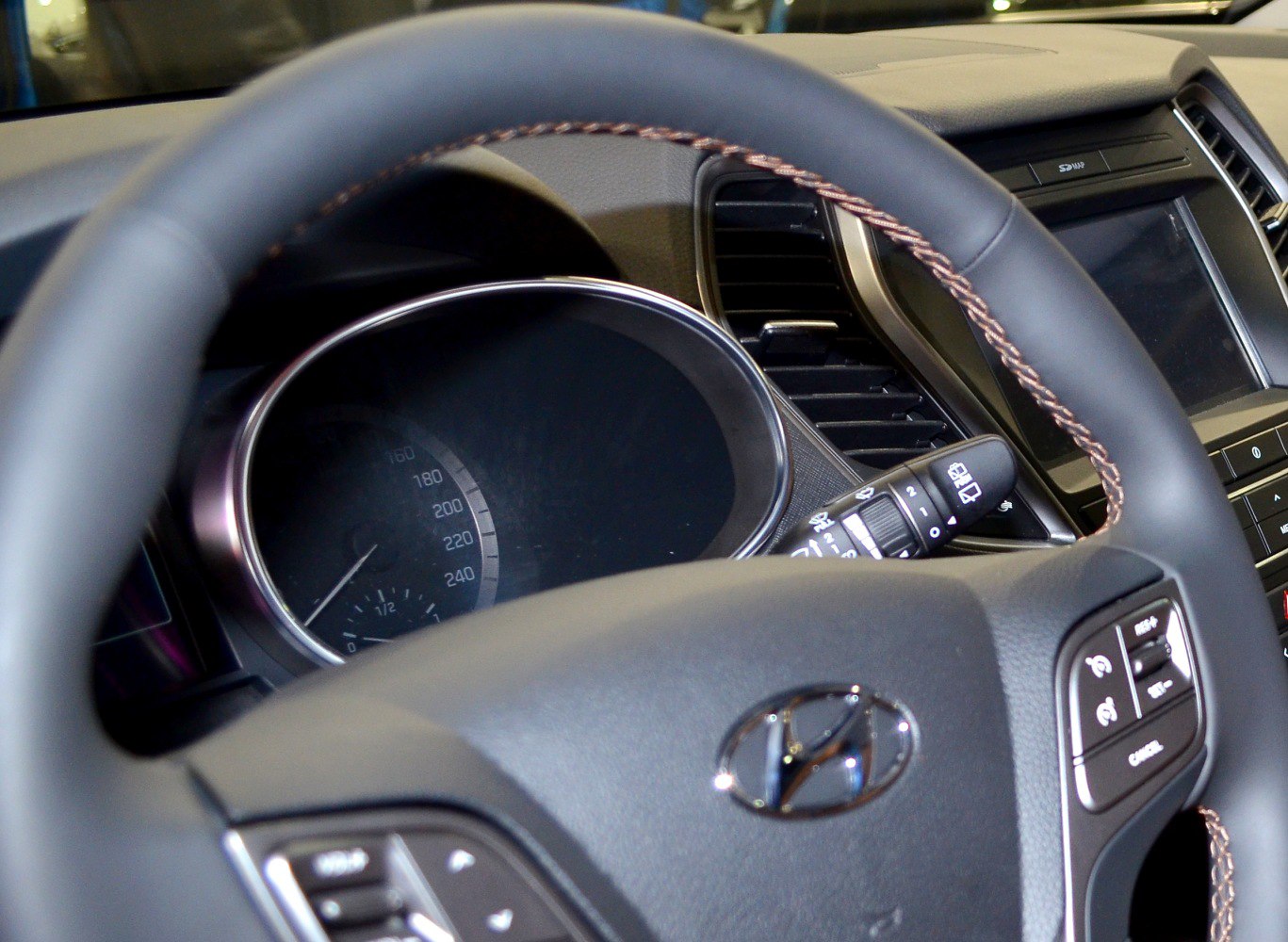 Steering wheel with control buttons and instrument cluster speedometer