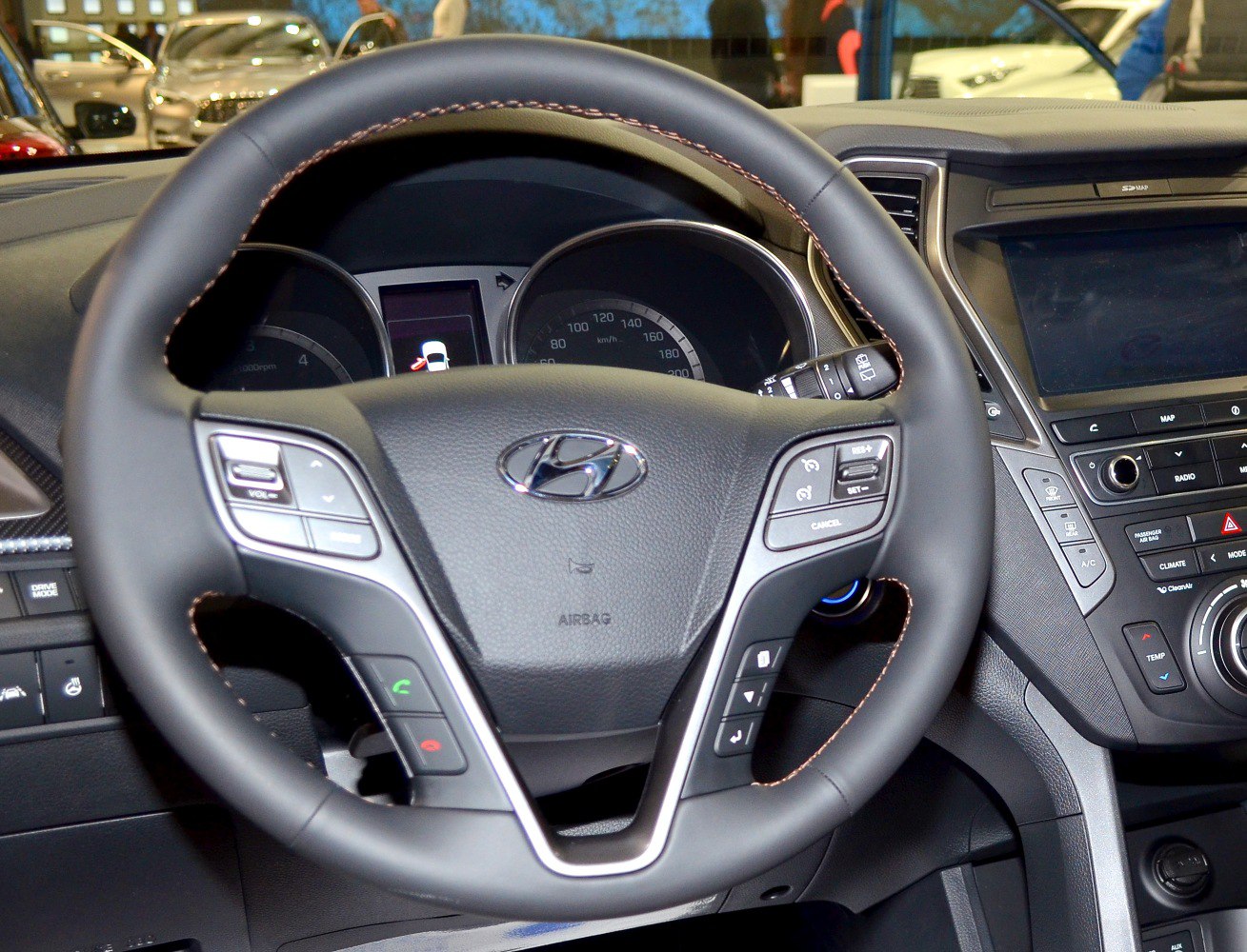 Steering wheel with control buttons and dashboard cluster in car interior