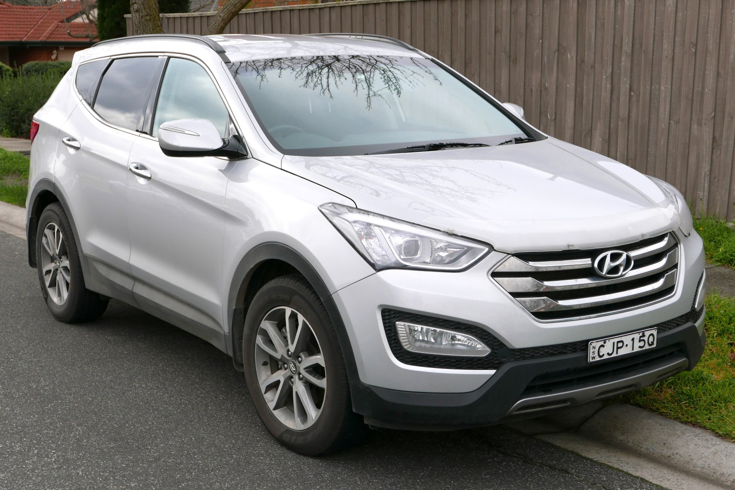 Front and side view of SUV featuring grille, headlights, and alloy wheels