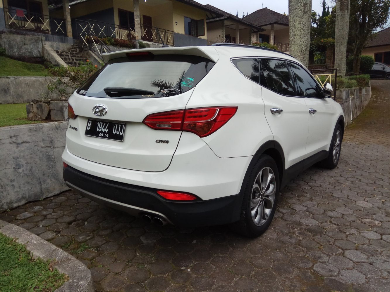 White SUV rear and side view with tail lights and exhaust pipes