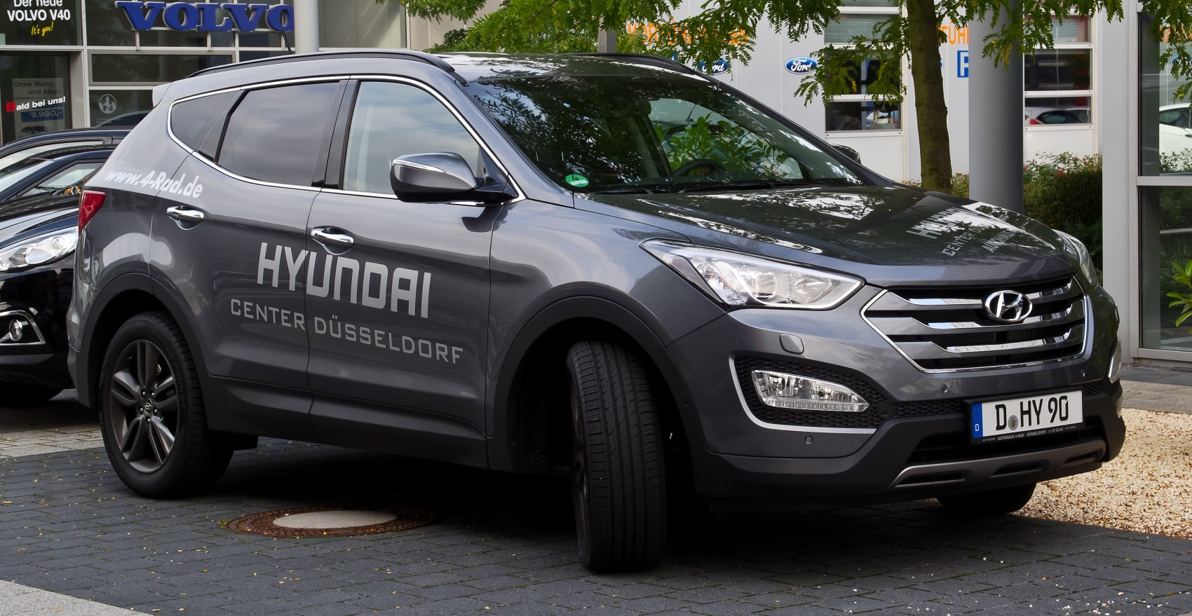 Front and side exterior view of a modern SUV with sleek headlights and alloy wheels