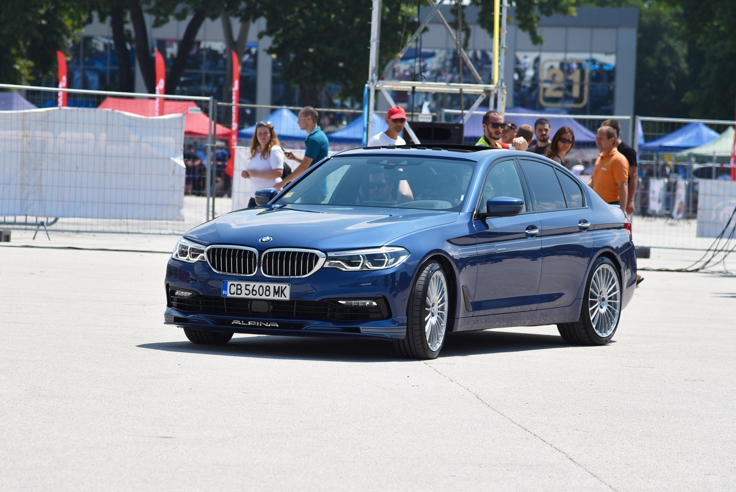 Blue luxury sedan with prominent front grille and multi-spoke alloy wheels
