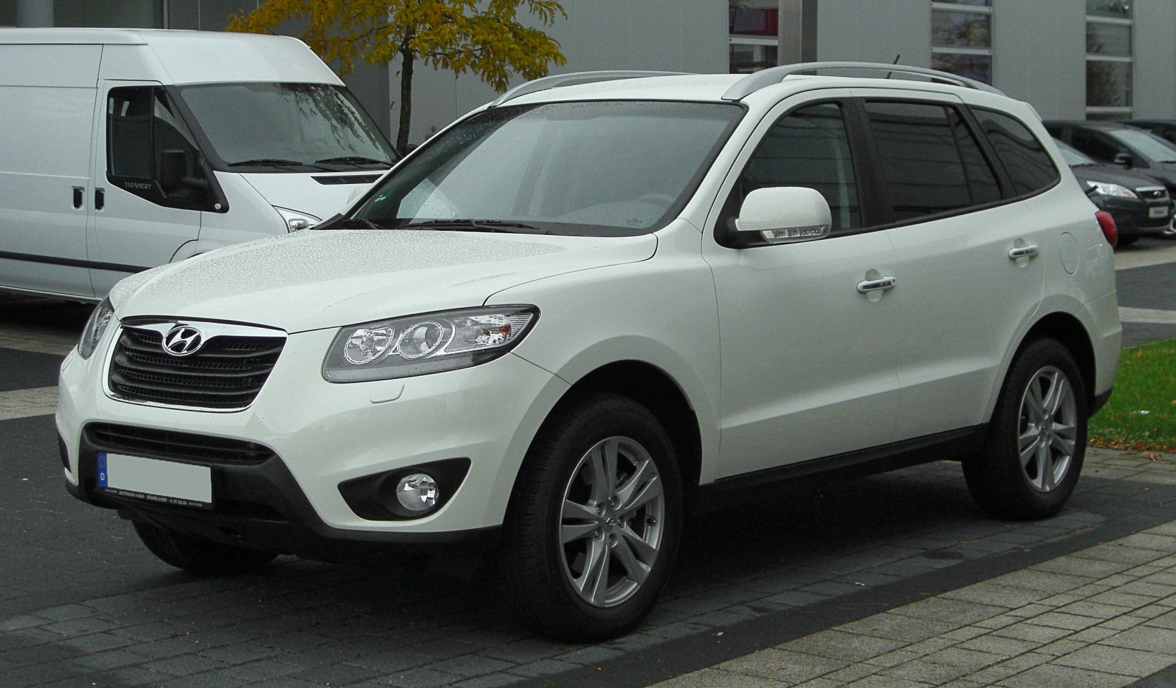 Front-side view of white SUV showing headlights and grille