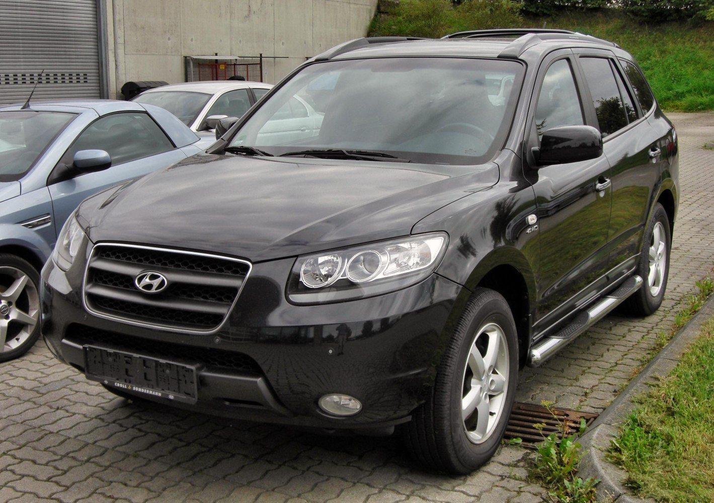 Black SUV front and side with alloy wheels, sleek headlights, and side steps