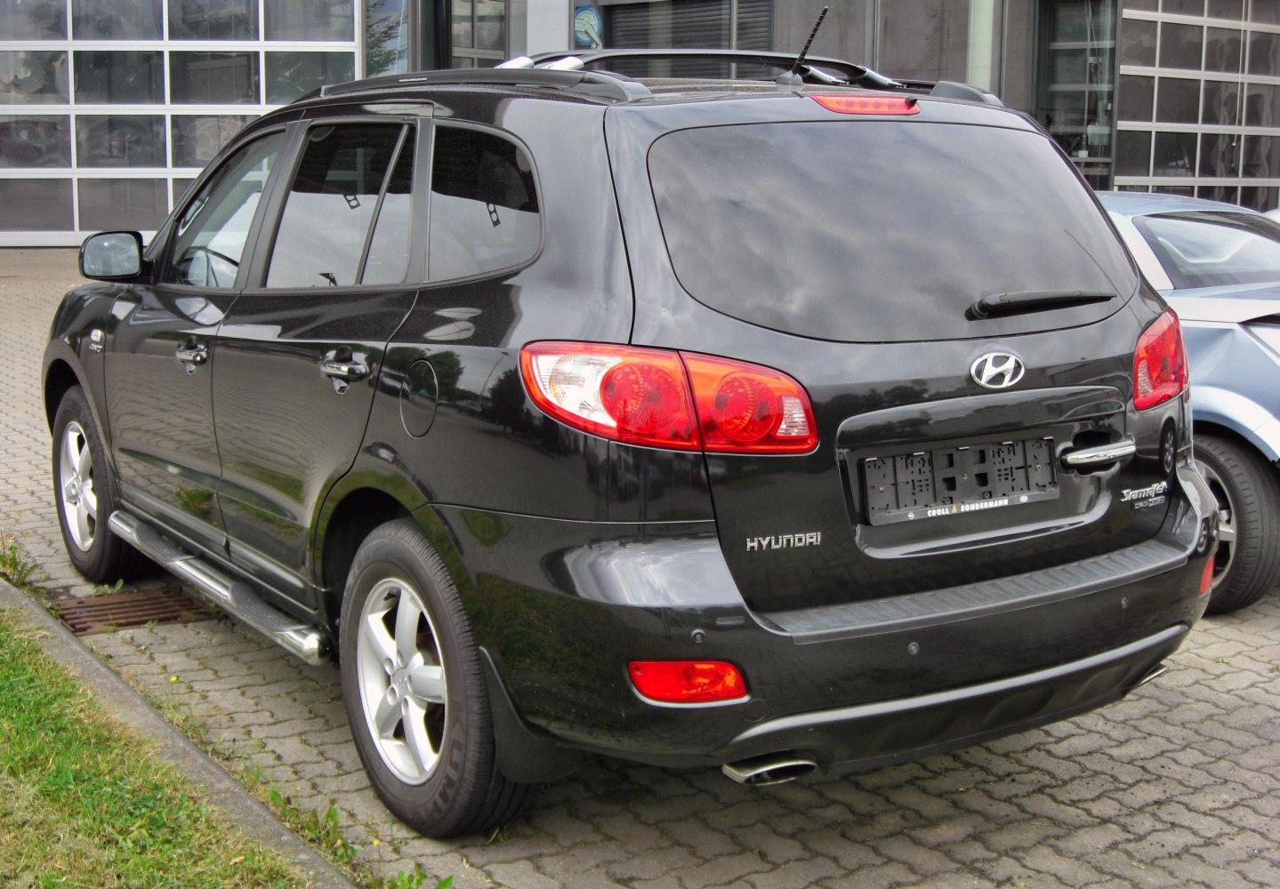 Rear side view of SUV with red tail lights and roof rails