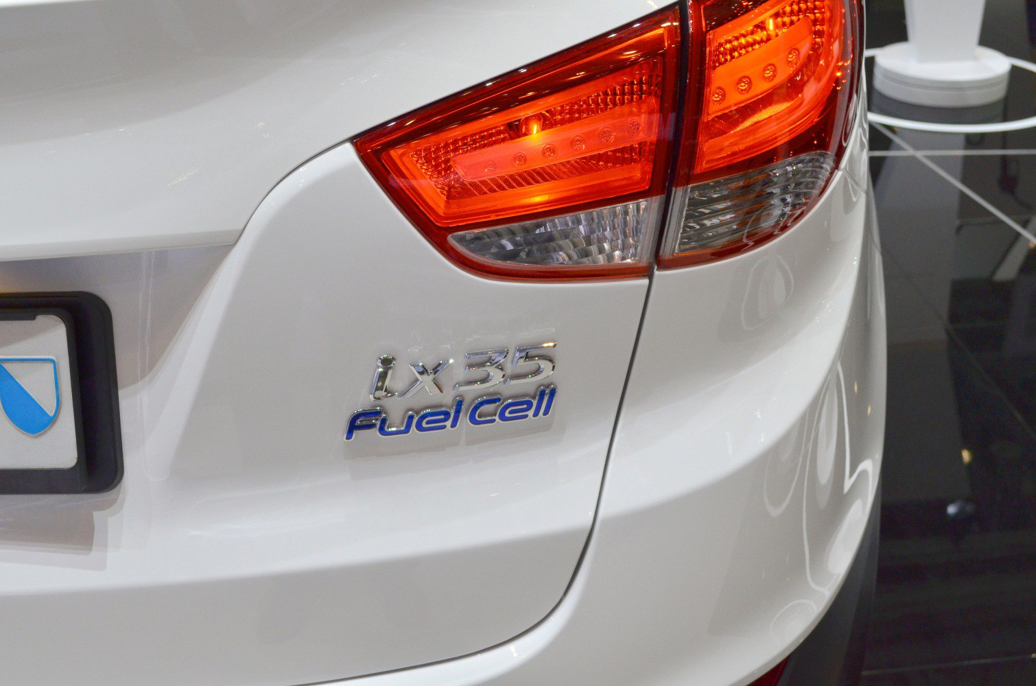 Close-up of rear taillight and fuel cell badge on white vehicle