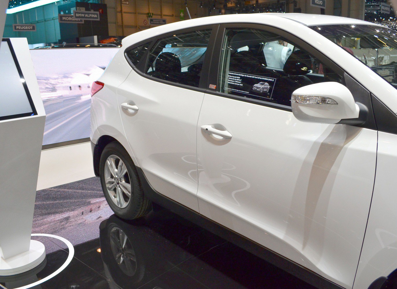 Side view showing front door handle, rear door, and alloy wheel.