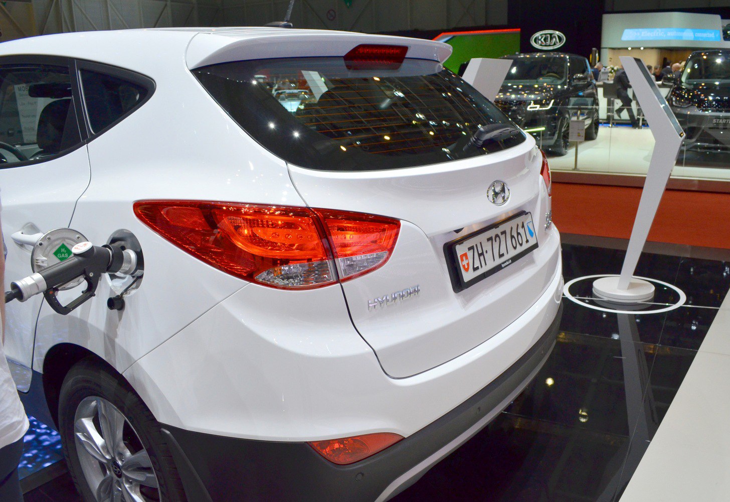 Rear view of white hatchback with hydrogen fuel nozzle attached
