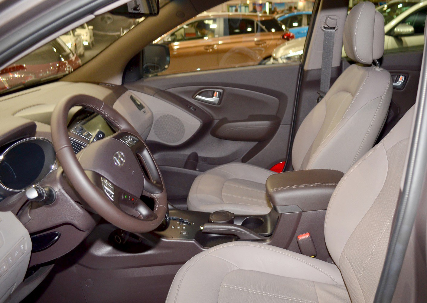 Steering wheel, dashboard, and front seats with beige upholstery in a car interior