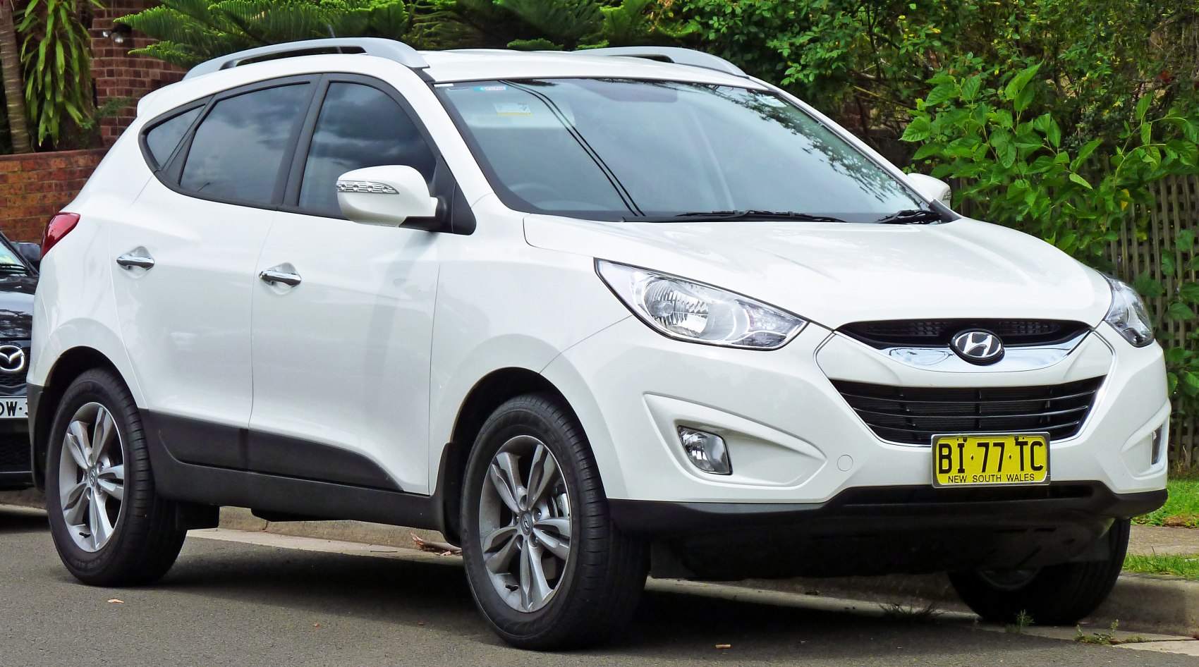 Front-side view with sharp headlights and hexagonal grille