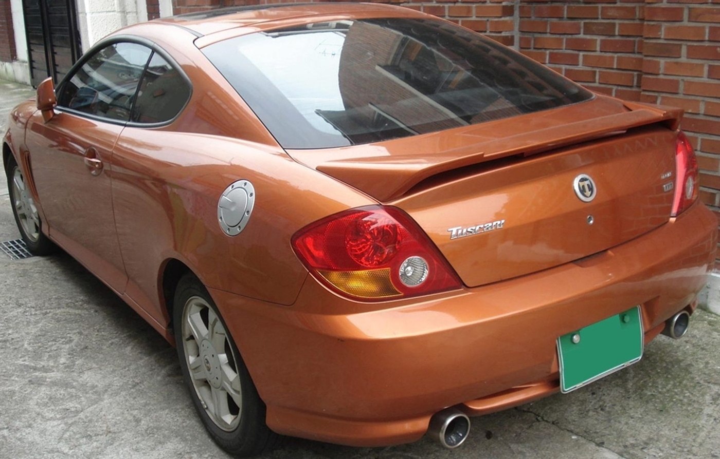 Rear view with spoiler, dual exhaust tips, and round fuel cap