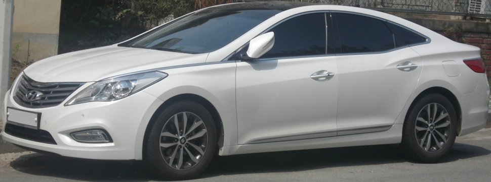 White sedan with alloy wheels and tinted windows side view