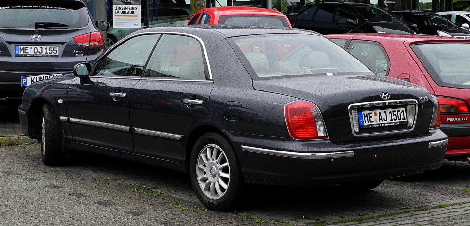 Rear and side view of a black luxury sedan with chrome trim and classic tail lights