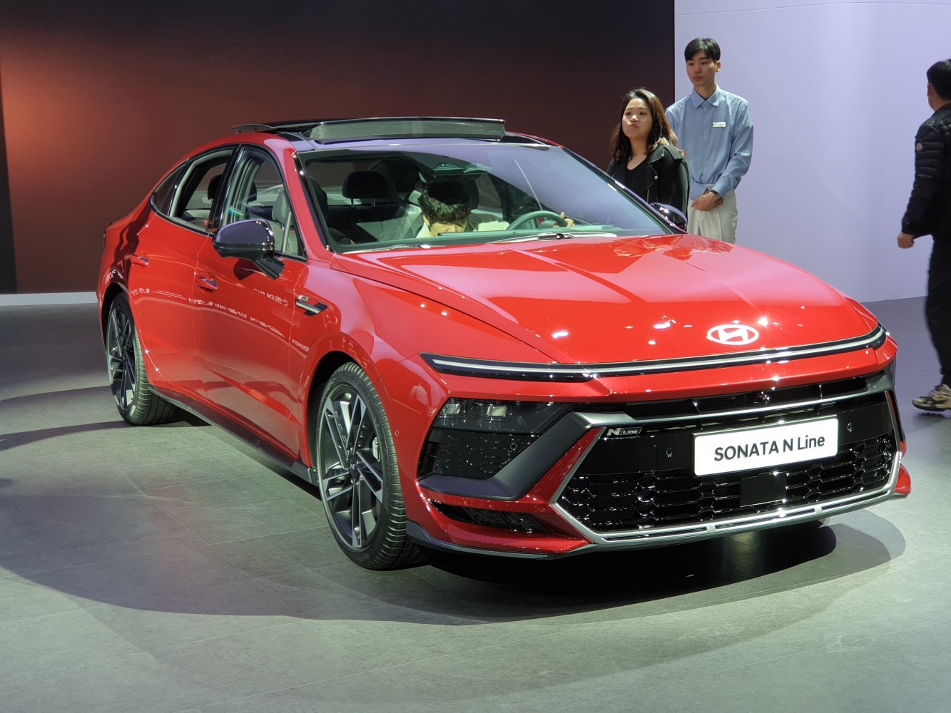 Red sedan with aggressive front grille and sleek LED headlights
