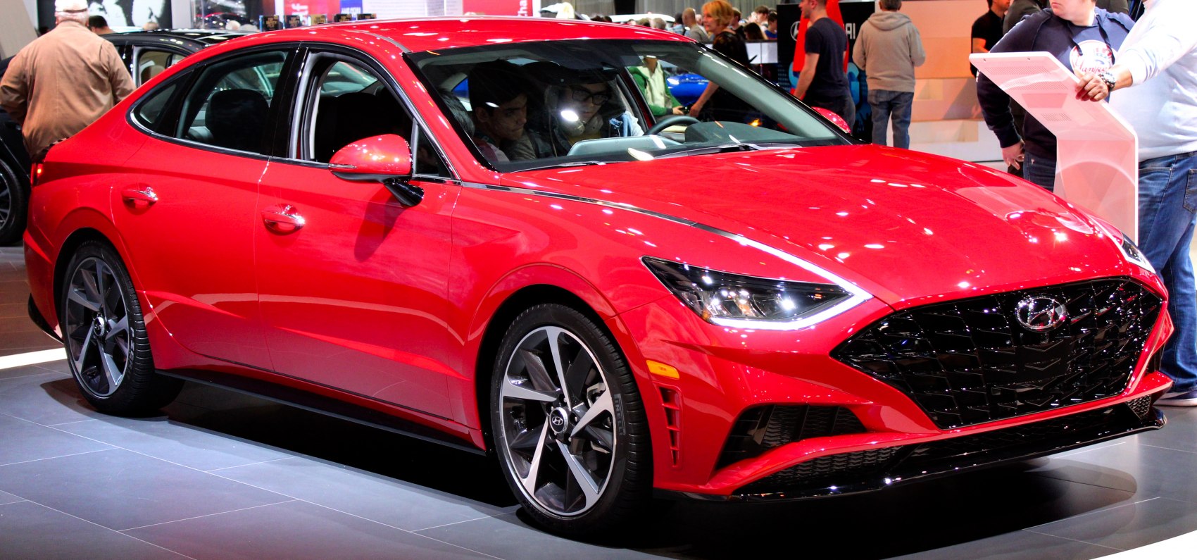 Red sedan with sharp headlights and black mesh grille