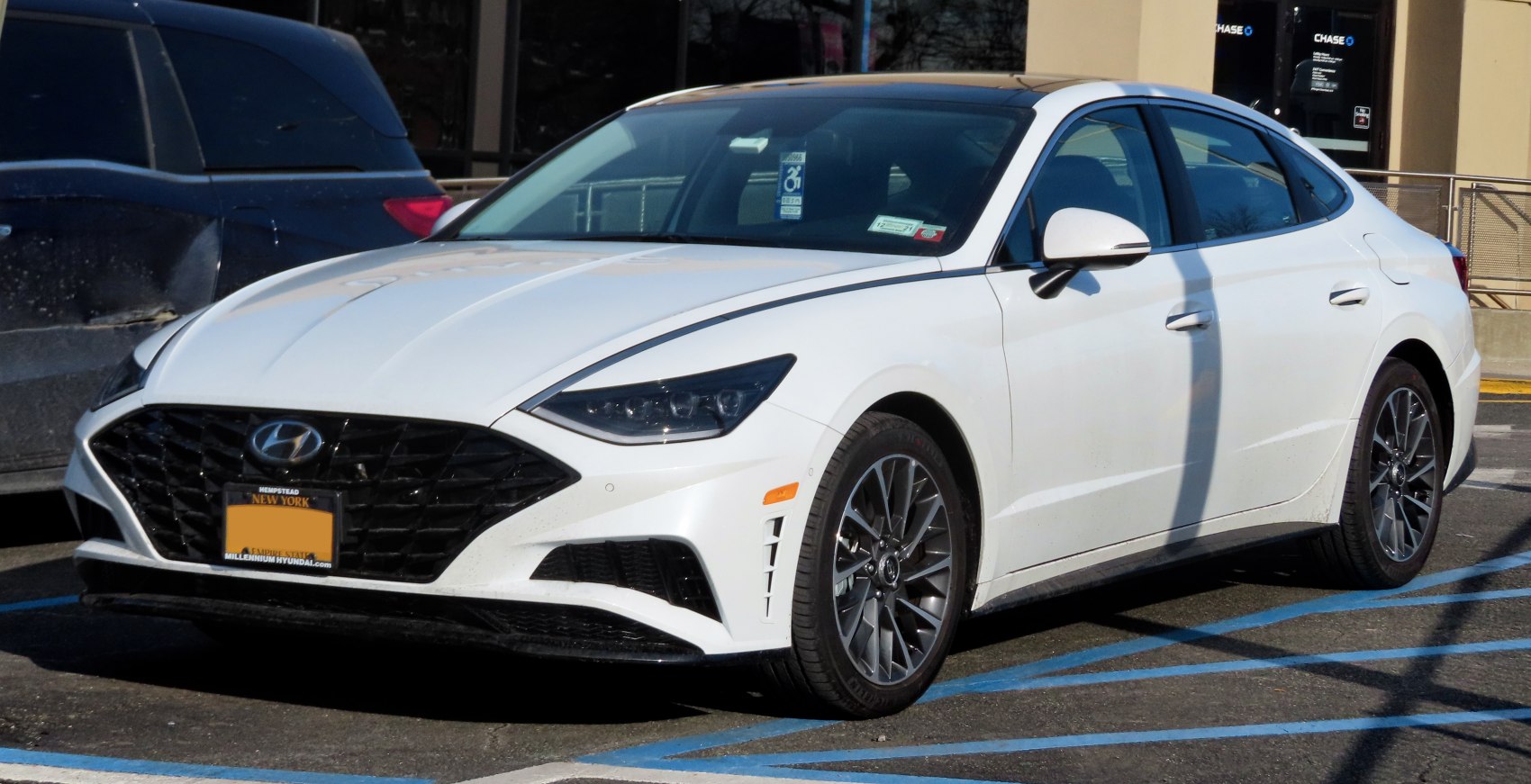 Front grille and sleek headlight design of a white sedan