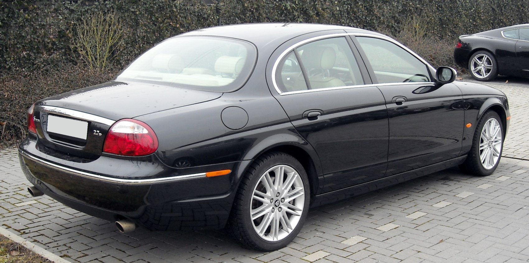 Rear side view with distinctive taillights, chrome trim, alloy wheels
