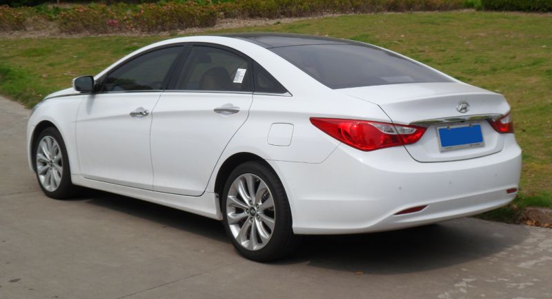 Rear side view of a white sedan with sleek taillights and alloy wheels